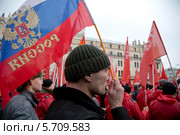 Мужчина держит российский триколор на митинге "В поддержку Крыма и против фашизма" на площади Революции города Москвы 15 марта 2014. Редакционное фото, фотограф Николай Винокуров / Фотобанк Лори