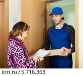 Работник сервисной службы принес посылку домохозяйке. Стоковое фото, фотограф Яков Филимонов / Фотобанк Лори
