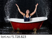 Мокрая девушка брызгается водой, сидя в ванной на черном фоне. Стоковое фото, фотограф Losevsky Pavel / Фотобанк Лори
