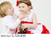 Двое веселых детей на светлом фоне. Мальчик собирается поцеловать девочку. Стоковое фото, фотограф Losevsky Pavel / Фотобанк Лори