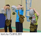 Дети надевают противогазы (2014 год). Редакционное фото, фотограф Вячеслав Палес / Фотобанк Лори