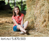 Юная девушка сидит в сарае рядом со стогом сена (2014 год). Редакционное фото, фотограф Игорь Низов / Фотобанк Лори