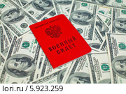 Военный билет гражданина Российской Федерации на фоне из 100-долларовых купюр. Стоковое фото, фотограф Александр Тарасенков / Фотобанк Лори
