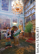 Православная женщина крестится перед иконой в праздник Троицы. Москва (2013 год). Редакционное фото, фотограф Ольга Липунова / Фотобанк Лори