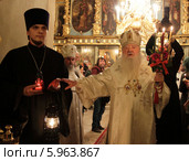 Пасха в Новодевичьем монастыре города Москвы. Митрополит Крутицкий и Коломенский Ювеналий принимает Благодатный огонь привезённый из Иерусалима (2014 год). Редакционное фото, фотограф Дмитрий Неумоин / Фотобанк Лори