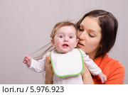 Шестимесячная девочка в слюнявчике рвет волосы у мамы. Стоковое фото, фотограф Иванов Алексей / Фотобанк Лори