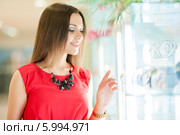 Красивая девушка с длинными волосами в красном платье делает покупки. Стоковое фото, фотограф Вера Франц / Фотобанк Лори