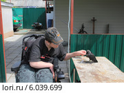 Мальчик-инвалид кормит галчонка. Стоковое фото, фотограф Татьяна Грин / Фотобанк Лори