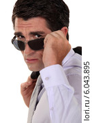 Businessman peering over his sunglasses. Стоковое фото, фотограф Phovoir Images / Фотобанк Лори