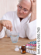 Unhappy senior citizen taking her medication. Стоковое фото, фотограф Phovoir Images / Фотобанк Лори
