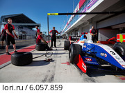 Команда механиков Fortec Motorsport тренируется менять колеса на болиде Формула 3.5 в гонках на чемпионате "Мировая серия Renault" на треке Moscow Raceway в Подмосковье (2014 год). Редакционное фото, фотограф Николай Винокуров / Фотобанк Лори