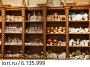 Посуда на полках в шкафу в магазине сувениров (2013 год). Редакционное фото, фотограф Ольга Липунова / Фотобанк Лори