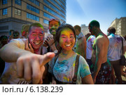 Посетители музыкального фестивале индийских красок ColorFest бросают друг друга сухой краской в Москве на проспекте Сахарова 13 июля 2014. Редакционное фото, фотограф Николай Винокуров / Фотобанк Лори