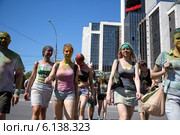 Посетители музыкального фестивале индийских красок ColorFest идут от проспекта Сахарова к метро на фоне офиса компании Лукойл в центре города Москвы (2014 год). Редакционное фото, фотограф Николай Винокуров / Фотобанк Лори