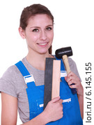 Female labourer holding mallet and sand paper. Стоковое фото, фотограф Phovoir Images / Фотобанк Лори