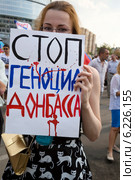 Девушка держит баннер с надписью "Стоп геноцид Донбасса" на митинге в поддержку Донбасса, Новороссии под названием "Битва за Донецкую Русь!", 2 августа 2014. Редакционное фото, фотограф Николай Винокуров / Фотобанк Лори