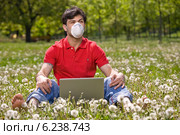 Young man sitting on the grass. Стоковое фото, агентство BE&W Photo / Фотобанк Лори