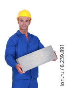Tradesman carrying a cinder block. Стоковое фото, фотограф Phovoir Images / Фотобанк Лори