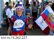 Российская болельщица с национальной аттрибутикой и флагом чемпионата мира по гребле на байдарках и каноэ в Москве на гребном канале Крылатское (2014 год). Редакционное фото, фотограф Николай Винокуров / Фотобанк Лори