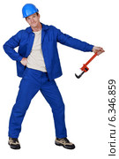 Goofy tradesman holding a pipe wrench. Стоковое фото, фотограф Phovoir Images / Фотобанк Лори