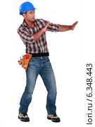Tradesman trying to protect himself from a shooting object. Стоковое фото, фотограф Phovoir Images / Фотобанк Лори