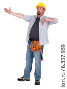 Tradesman pointing to an object and giving the thumb's down. Стоковое фото, фотограф Phovoir Images / Фотобанк Лори
