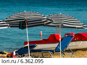 Пляжные зонтики, лежаки и катамаран на берегу моря. Стоковое фото, фотограф Мальцев Артур / Фотобанк Лори