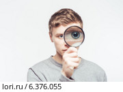 Man looking through a magnifying glass. Стоковое фото, агентство Ingram Publishing / Фотобанк Лори