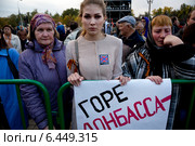 Активистка НОД Катасонова Мария Владимировна (в центре) держит плакат "Горе - Донбасса, Горе - России" на акции скорби "Донецк: невинно убиенные" по погибшим мирным жителям в войне на Украине на Поклонной горе у памятника "Трагедия народов", Москва (2014 год). Редакционное фото, фотограф Николай Винокуров / Фотобанк Лори