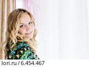 Девушка в пёстром платье перед белыми шторами у окна. Стоковое фото, фотограф Валерия Лузина / Фотобанк Лори
