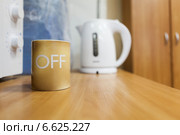 Чашка с надписью OFF стоит на краю стола. Стоковое фото, фотограф Кекяляйнен Андрей / Фотобанк Лори