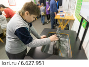 Мальчик в "Экспериментаниуме" в Москве. Опыт с магнитами (2014 год). Редакционное фото, фотограф Володина Ольга / Фотобанк Лори