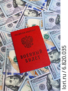 Военный билет гражданина Российской Федерации на фоне из 100-долларовых купюр. Стоковое фото, фотограф Александр Тарасенков / Фотобанк Лори
