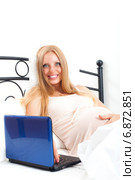 Smiling beautiful pregnant blond with laptop lying in bed. Стоковое фото, фотограф Яков Филимонов / Фотобанк Лори