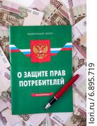 Закон о защите прав потребителей и перьевая ручка на фоне сторублёвых купюр. Стоковое фото, фотограф Литвяк Игорь / Фотобанк Лори