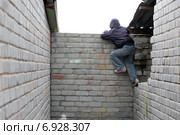 Мальчик перелезает через каменную ограду. Стоковое фото, фотограф Данилова Наталья / Фотобанк Лори