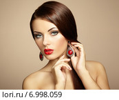 Portrait of beautiful brunette woman with earring. Perfect makeup. Стоковое фото, агентство Ingram Publishing / Фотобанк Лори