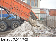 Разгрузка грязного снега из кузова самосвала в снегодробилку на снегоплавильном пункте, Москва (2015 год). Редакционное фото, фотограф Малышев Андрей / Фотобанк Лори