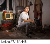 Мужчина с чайником в руках сидит в грязной неубранной квартире. Стоковое фото, фотограф Вячеслав Николаенко / Фотобанк Лори