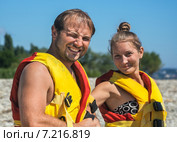 Молодая пара надевает плавательные жилеты на пляже. Стоковое фото, фотограф Светлана Кузнецова / Фотобанк Лори