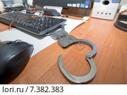 Свобода. Наручники открытые скрепкой лежат на столе офисного служащего (2015 год). Редакционное фото, фотограф Pukhov K / Фотобанк Лори
