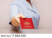 Женщина протягивает заграничный паспорт Российской Федерации (фокус на паспорте) Стоковое фото, фотограф Анна Менщикова / Фотобанк Лори