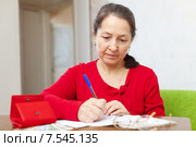 mature woman fills utility bills. Стоковое фото, фотограф Яков Филимонов / Фотобанк Лори