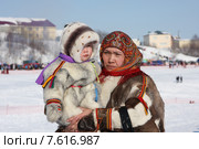 Женщина с ребенком на руках в меховой национальной одежде на дне оленевода в Салехарде (2013 год). Редакционное фото, фотограф Елена Боброва / Фотобанк Лори