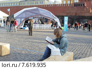 Московский фестиваль "Книги России" 2015 на Красной площади, молодой человек зачитался книгой. Редакционное фото, фотограф Дмитрий Неумоин / Фотобанк Лори