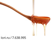 Honey dripping from a wooden honey dipper isolated on white background cutout. Стоковое фото, фотограф Natalja Stotika / Фотобанк Лори