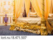 Роскошная спальня с кроватью с балдахином в золотых тонах. Стоковое фото, фотограф Константин Лабунский / Фотобанк Лори