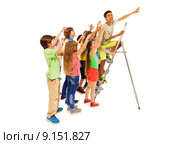 Мальчик стоит на лестнице на белом фоне с друзьями, которые хотят взобраться на лестницу, достижение цели. Стоковое фото, фотограф Сергей Новиков / Фотобанк Лори