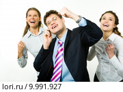 Portrait of three business partners holding their arms up and looking upwards with businessman speaking on the phone. Стоковое фото, фотограф Dmitriy Shironosov / PantherMedia / Фотобанк Лори