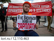 Участники митинга держат плакат с надписью "За коммунальный грабеж народа - правителсьство в отставку!" на акции протеста против социально-экономической политики Правительства РФ в центре города Москвы, Россия (2015 год). Редакционное фото, фотограф Николай Винокуров / Фотобанк Лори